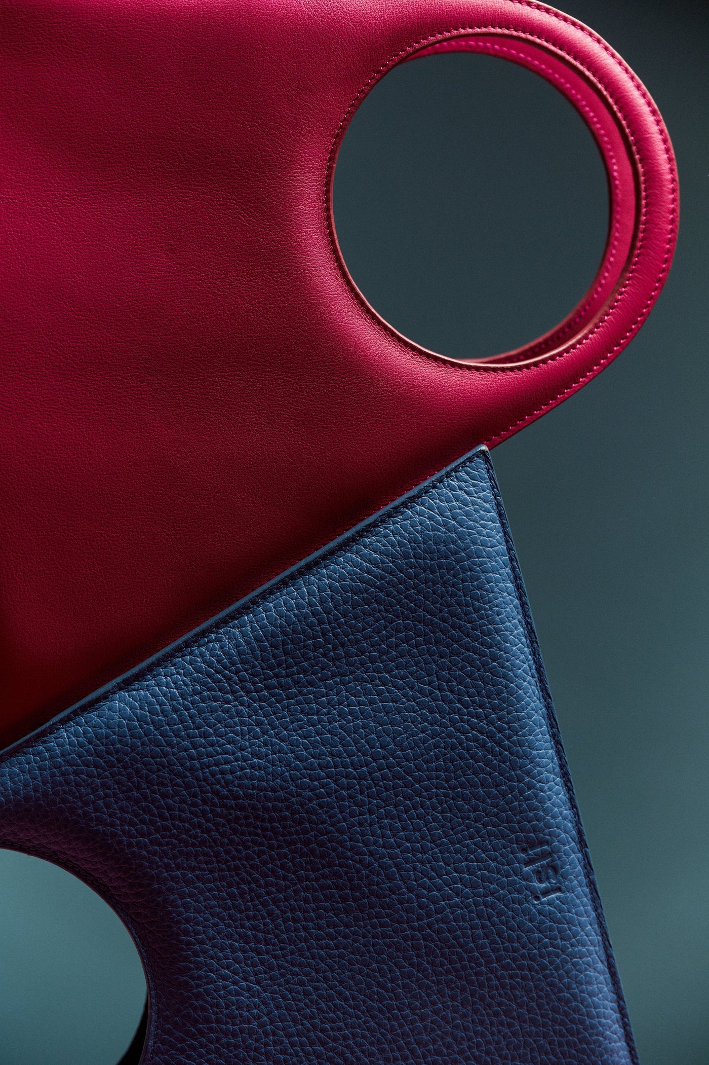 Close up of red smooth leather and blue grained leather on two ISLI Studio bags