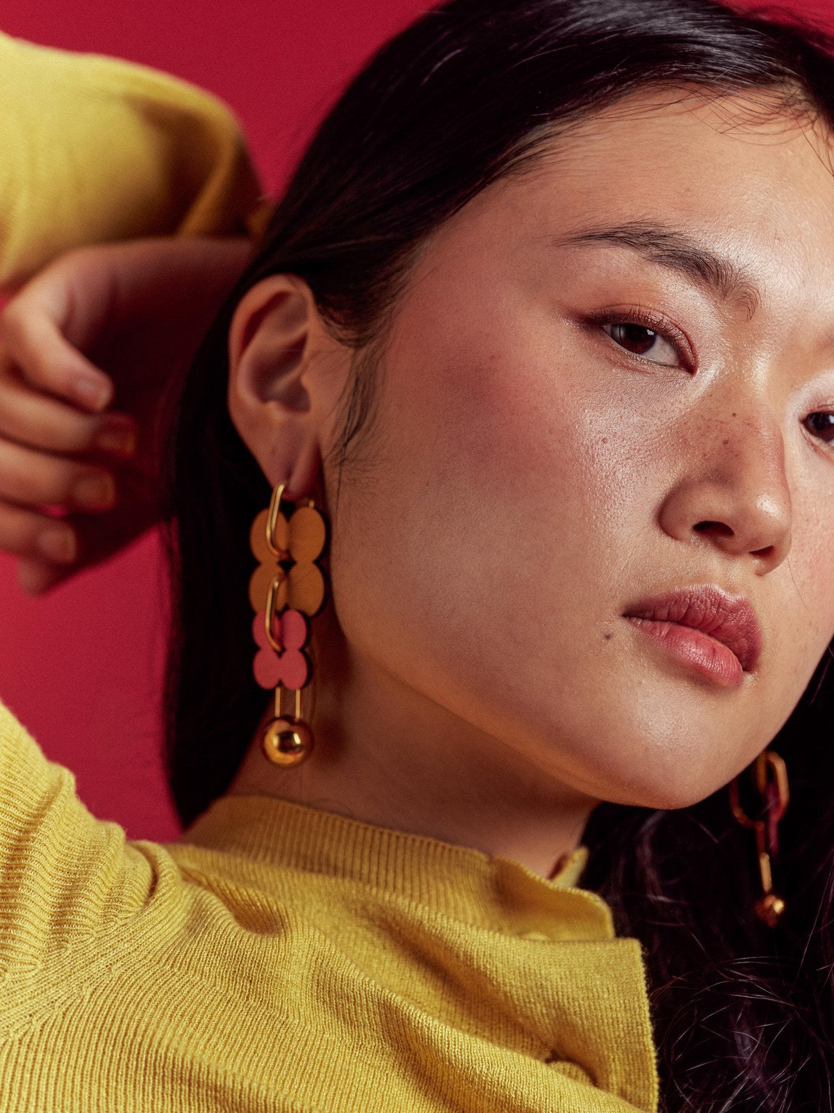 ISLI Studio statement earrings photographed close up on a coloured backdrop