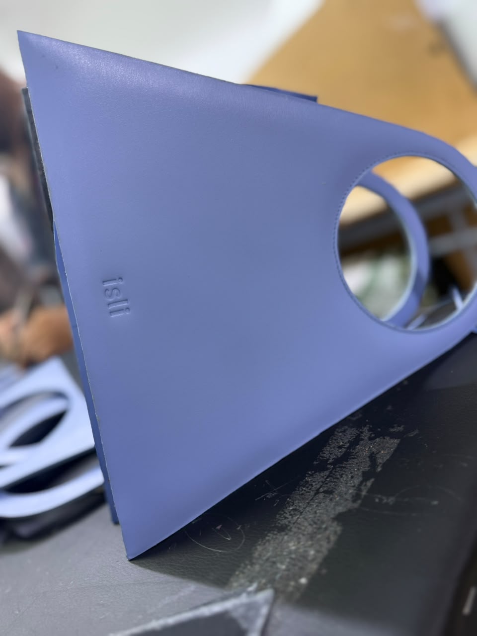 A periwinkle Toubkal bag showing its circular handle and the embossed isli mark.