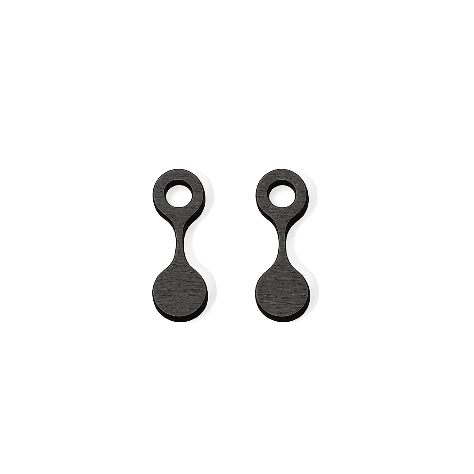Paire de charms en bois laqué noir, forme d'haltère à deux disques relies par une barre étroite, le disque supérieur ajouré.